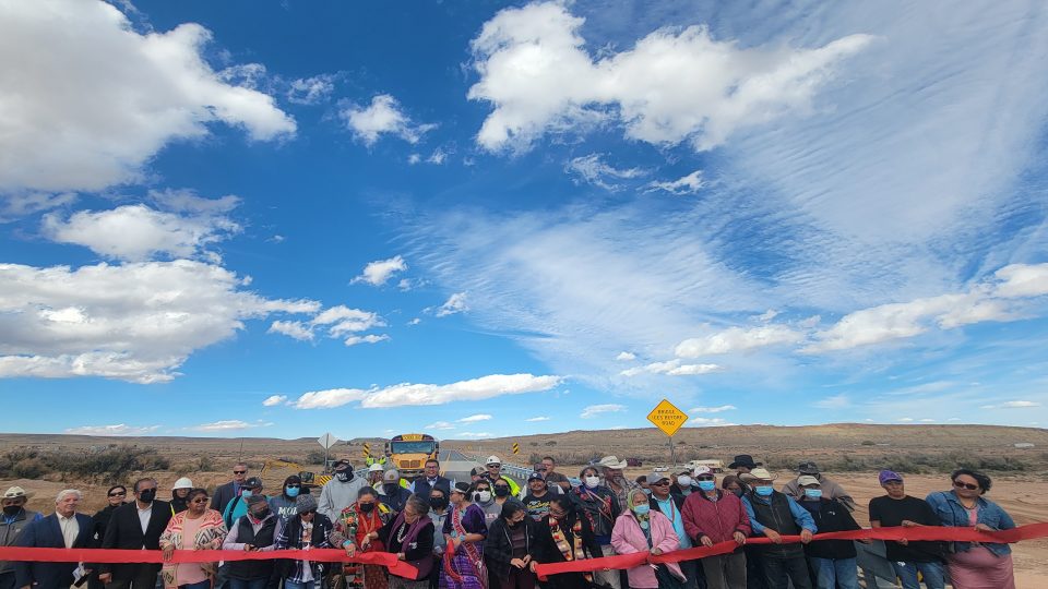 Local community members and officials gather to cut the ribbon on the newly constructed Sanostee Bridge.